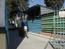 Man pushing  garbage cart labeled "UN"